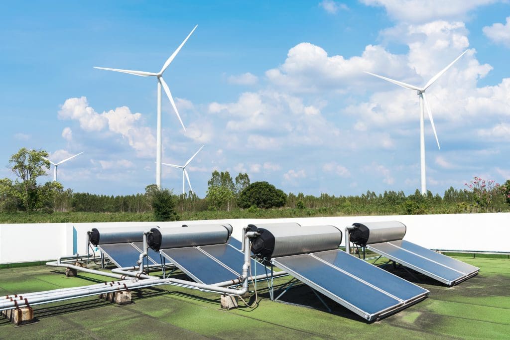 Solar cell energy panels and wind turbines with blue sky. Green